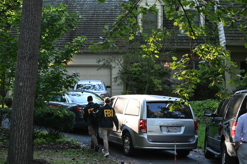 FBI agents walk outside the house of John Bolton at his place on August 22, 2025 in Bethesda, Maryland.