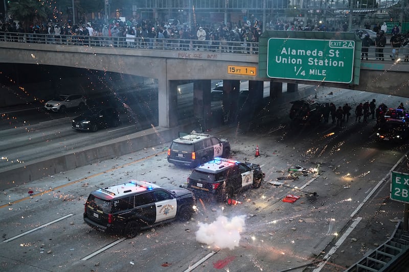 A flash bomb explodes on the 101 Freeway near the metropolitan detention center of downtown Los Angeles, California on June 8, 2025, following an immigration raid protest.