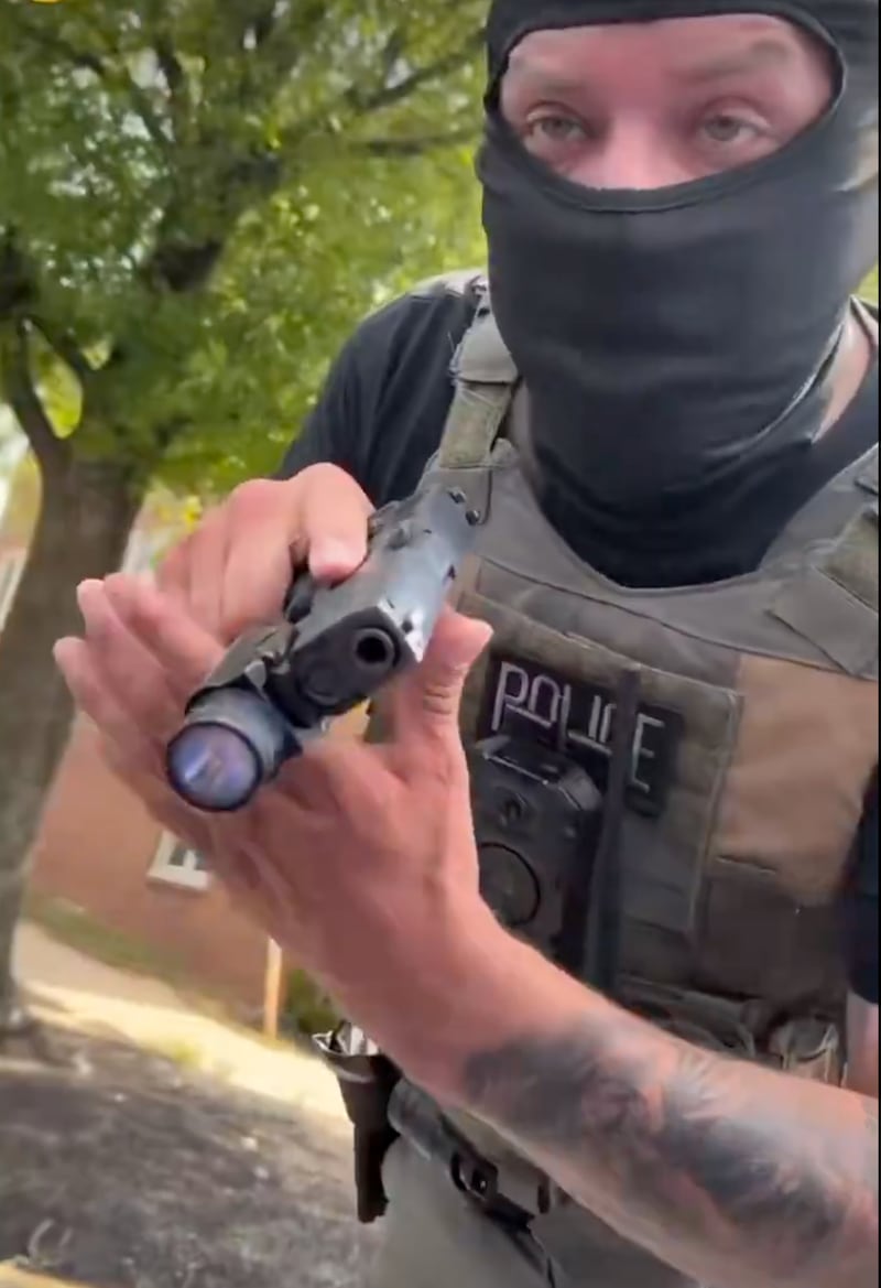 ICE agent pointing his gun.