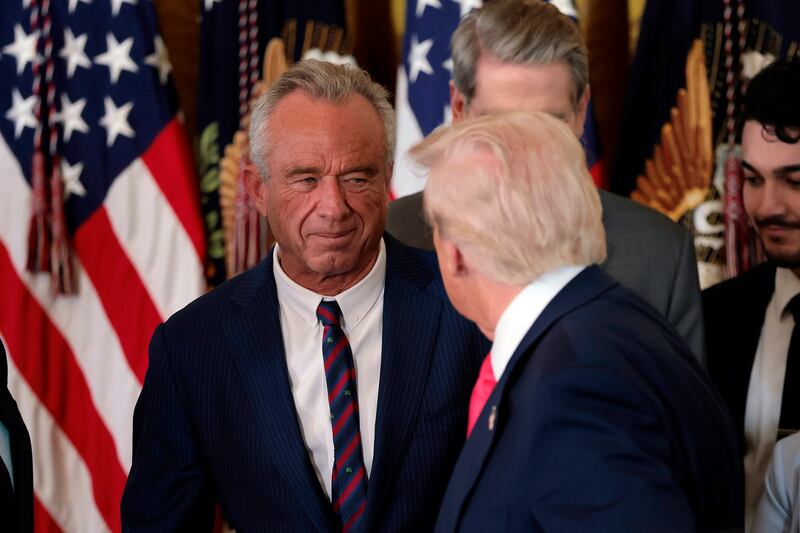 WASHINGTON, DC - NOVEMBER 13: President Donald Trump, shakes hands with Health and Human Services Secretary Robert F. Kennedy Jr. alongside Secretary of Housing and Urban Development Scott Turner (L) after Trump signed the "Fostering the Future" executive order the East Room of the White House on November 13, 2025 in Washington, DC. The executive order, championed by first lady Melania Trump, works to expand opportunities for education, career development, housing and other resources for youth transitioning from foster care to adulthood.  (Photo by Heather Diehl/Getty Images)