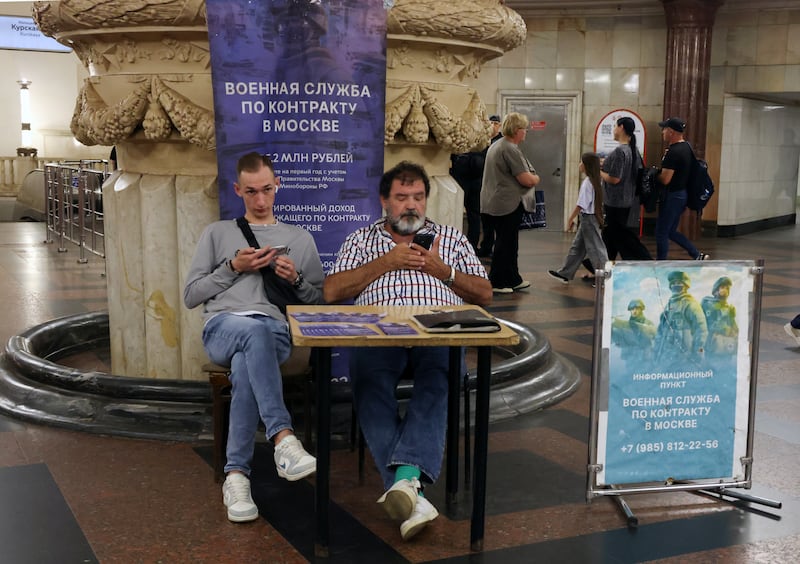MOSCOW, RUSSIA - JULY 23: Campaigners at the recruitment center for contract military service in the war with Ukraine sit in the metro station lobby, on July 23, 2026, in Moscow, Russia. The posters read: "Contract military service in Moscow. Starting from 5.5 million rubles". (Photo by Contributor/Getty Images)