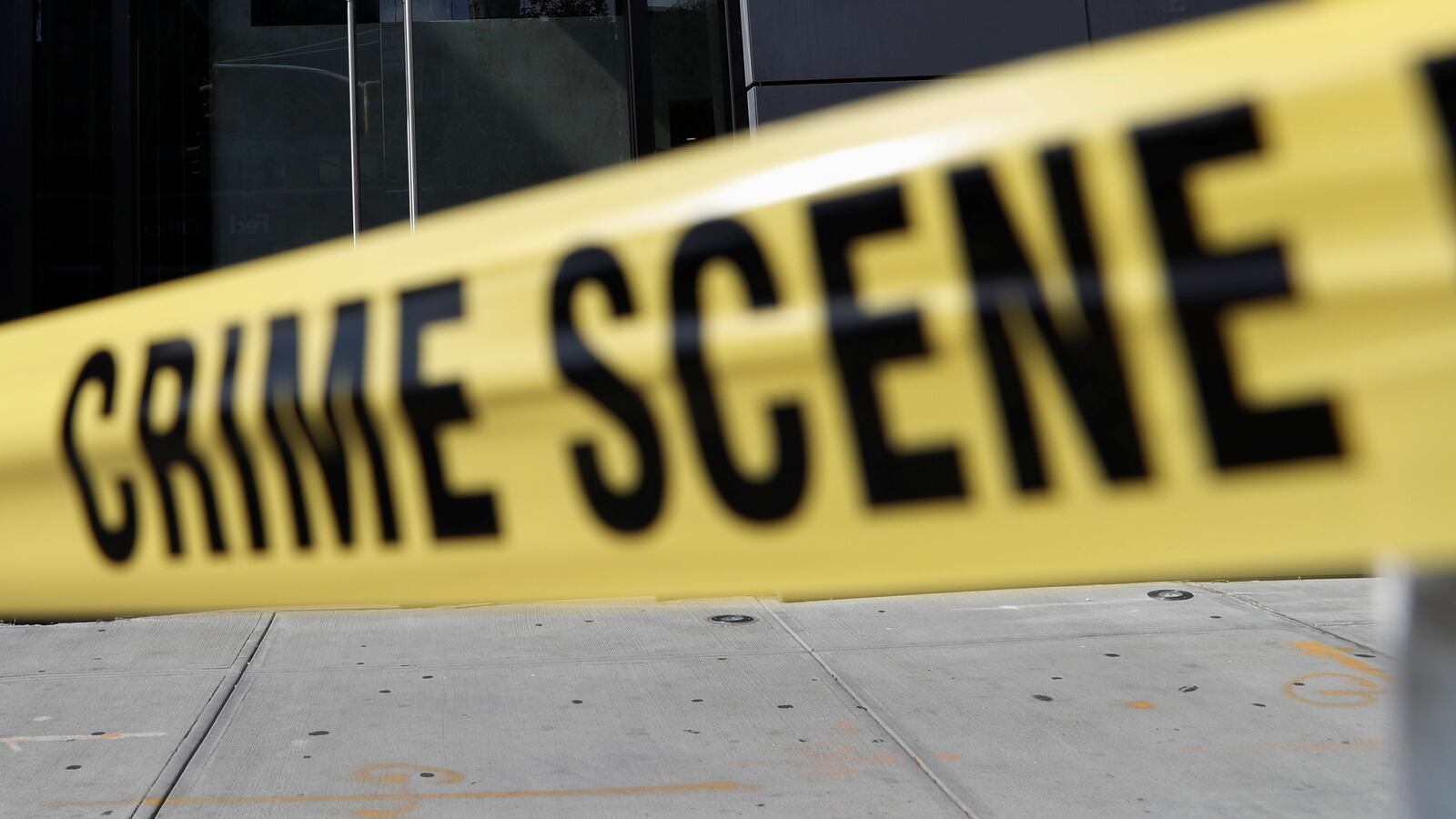 Crime scene tape blocks the entrance of a crime scene.