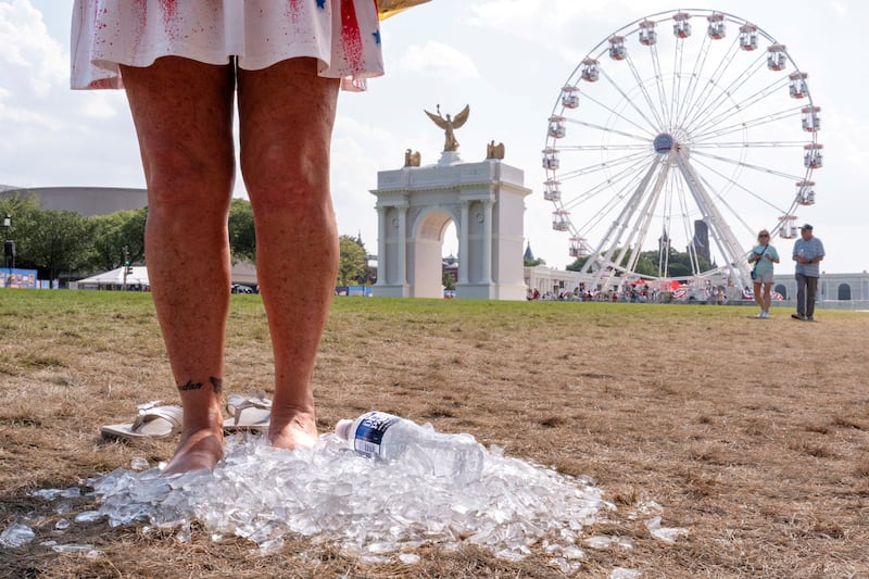 A woman stands in a pile of ice to cool off at The Great American State Fair on the National Mall amid a heatwave in Washington, D.C., U.S., July 1, 2026.