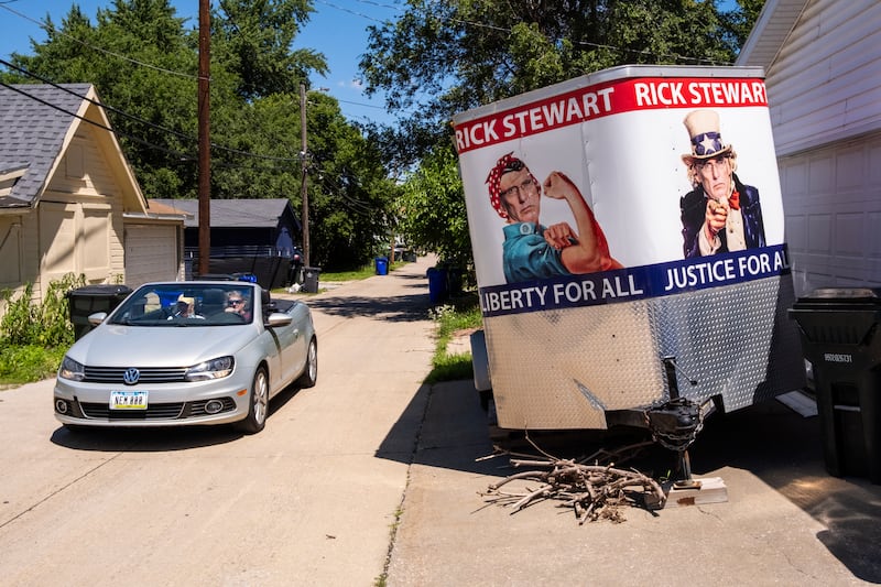 A car drives past a trailer used by Rick Stewart, a Libertarian candidate for U.S. House in Iowa's second congressional district, at his home in Cedar Rapids, Iowa on Saturday, June 20, 2026.