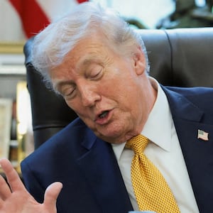 U.S. President Donald Trump looks at a model of a B‑2 bomber commemorating "Operation Midnight Hammer" during an event to sign an executive order creating an anti‑fraud task force headed by U.S. Vice President JD Vance in the Oval Office at the White House in Washington, D.C., U.S., March 16, 2026.