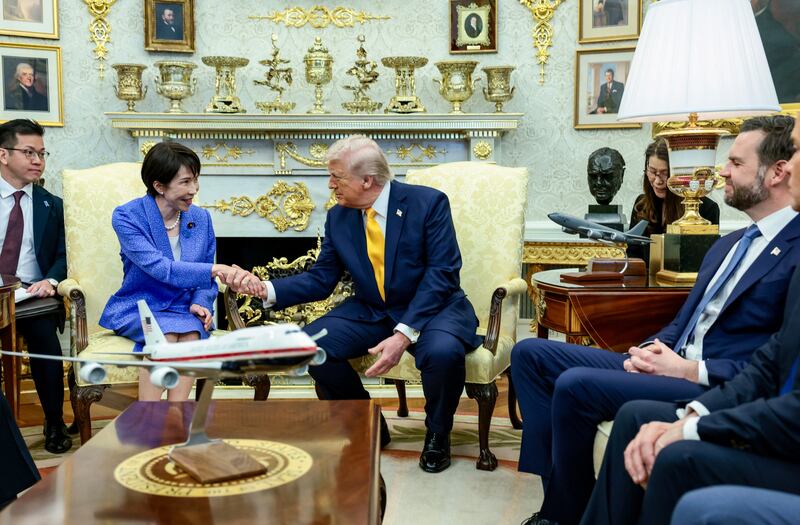 President Donald Trump shakes hands with Japanese Prime Minister Sanae Takaichi with gold ornaments and decoration in the background. REUTERS/Evelyn Hockstein.