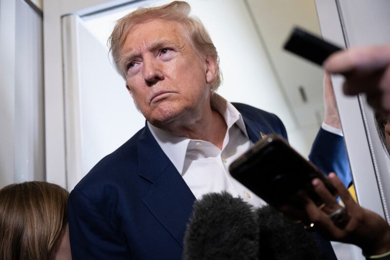 US President Donald Trump listens to questions from reporters aboard Air Force One over the United Kingdom on July 29, 2025, as he returns to Washington following a trip to Scotland.