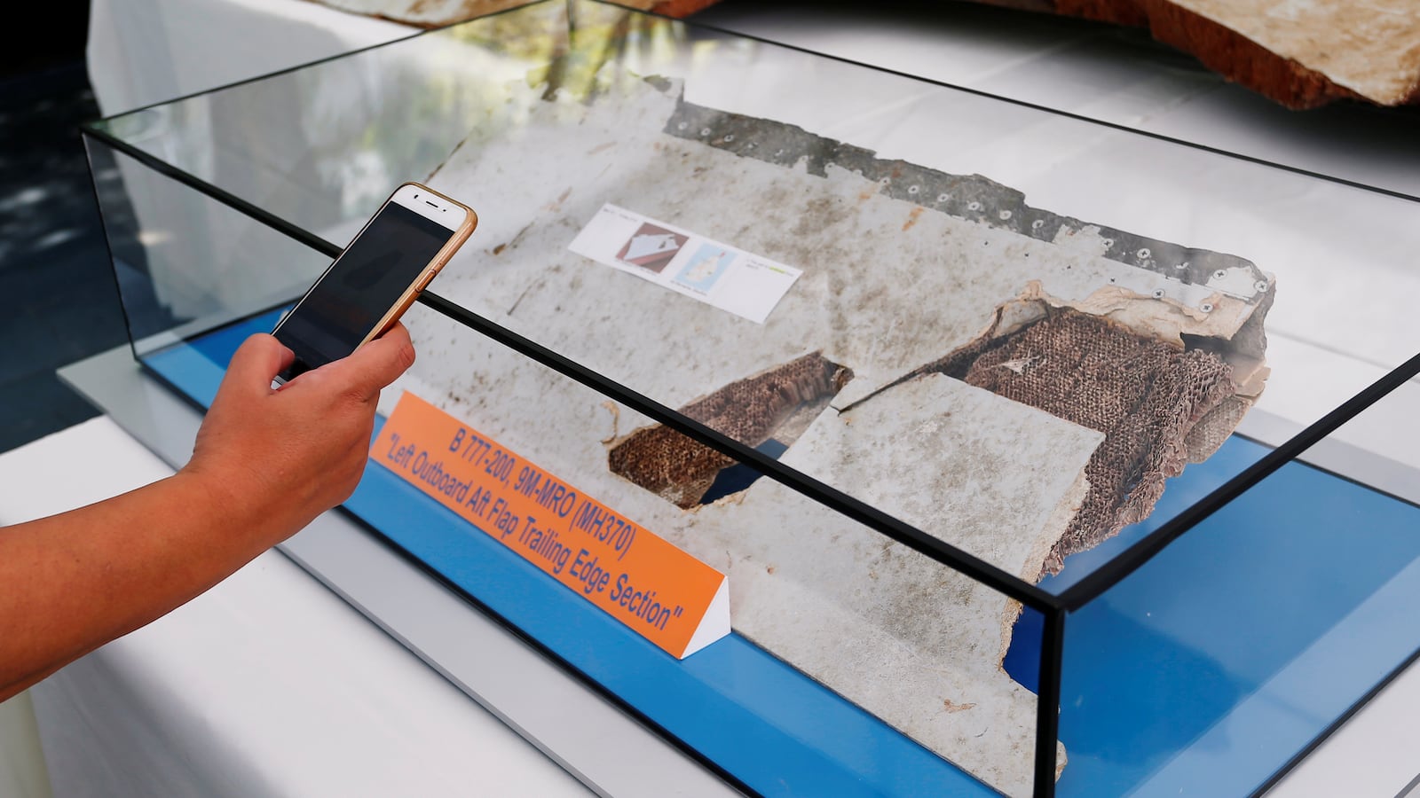 A man takes a photo of debris of the missing Malaysia Airlines MH370 during its fifth annual remembrance event in Kuala Lumpur, Malaysia, March 3, 2019.