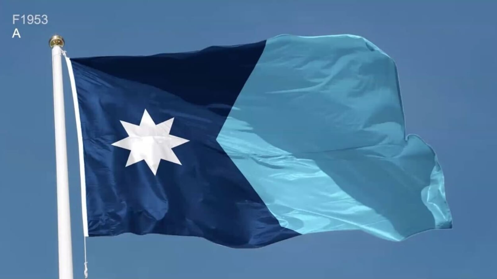 The new flag of Minnesota flying, showing its light and dark blue blocks with a white start on the left.