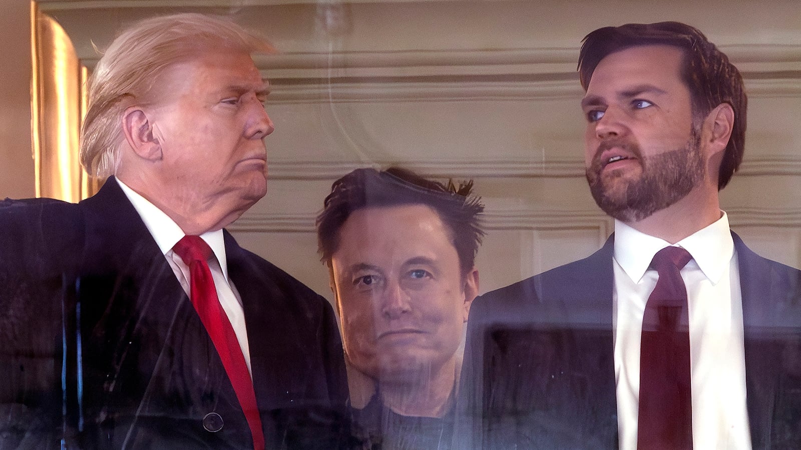 Donald Trump looks at JD Vance. In between them Elon Musk is grinning.