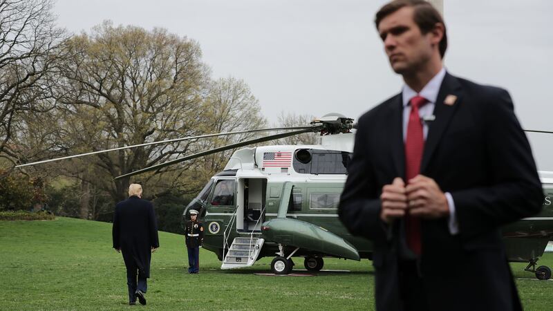 WASHINGTON, DC - APRIL 05:  A U.S. Secret Service agent stands watch as President Donald Trump walks across the South Lawn before boarding Marine One at the White House April 05, 2019 in Washington, DC. Trump is traveling to Southern California to visit the U.S.-Mexico border and to Beverly Hills for a fundraiser.  (Photo by Chip Somodevilla/Getty Images)