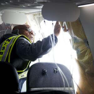 National Transportation Safety Board Investigator-in-Charge John Lovell examines the fuselage plug area of Alaska Airlines Flight 1282 Boeing 737-9 MAX on January 7, 2024 in Portland, Oregon