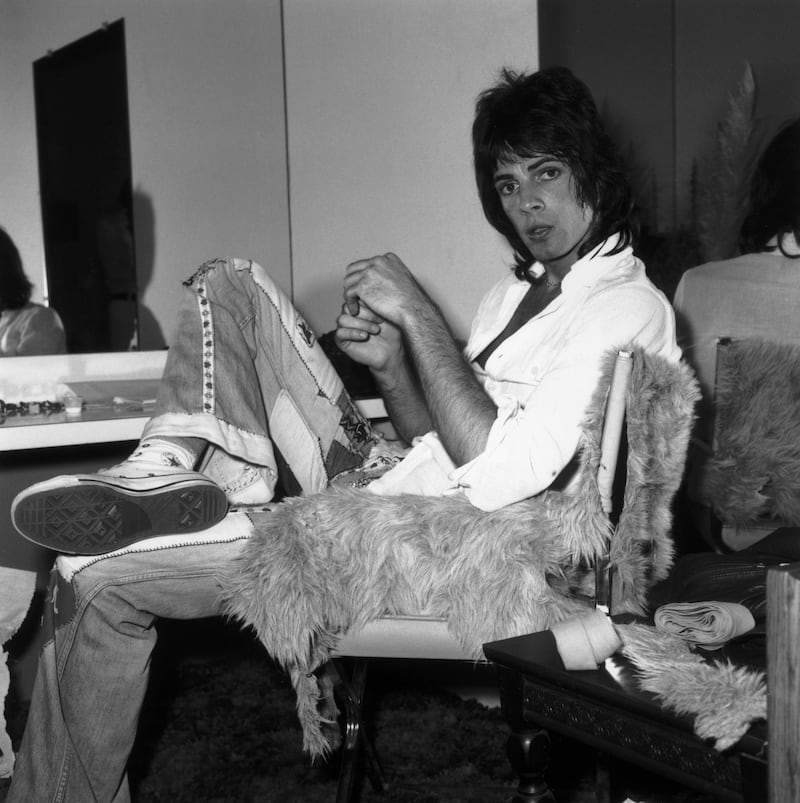 15th June 1974: Australian-born actor and pop singer Rick Springfield sits on a fur-covered chair backstage in his dressing room before a concert at Knotts Berry Farm. Anaheim, California. He wears patchwork bell-bottom jeans and white hightop Converse sneakers. (Photo by Frank Edwards/Fotos International/Getty Images)