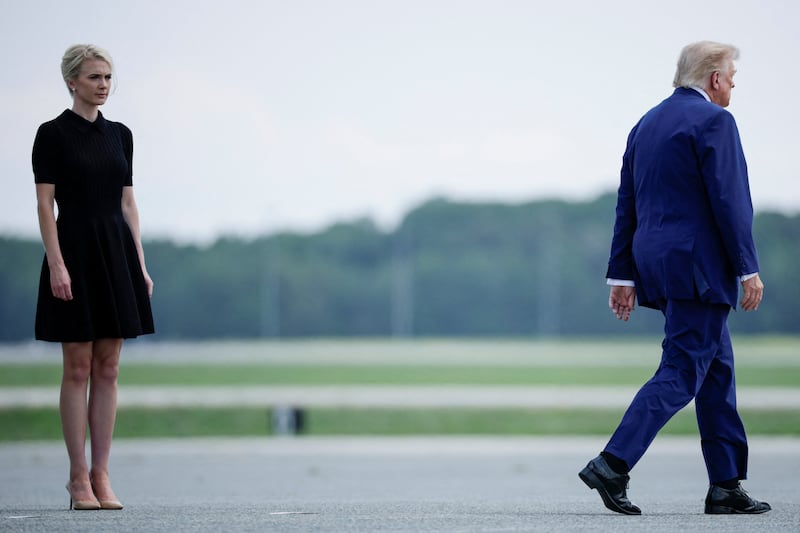 U.S. President Trump walks by his Executive assistant Natalie Harp as they attend a dignified transfer of the remains of U.S. Army service members, Army 1st Lt Tyler James Feehan, Sgt. Angel S. Rampersad, Pvt. Isabella Gonzales, killed during an attack on Muwaffaq Salti Air Base in Jordan, and Sgt. Michael Emmanuel Swinton, killed in action during a controlled detonation of a downed one-way unmanned aerial system at Erbil Air Base in Iraq, at Dover Air Force Base in Dover, Delaware, U.S., July 22, 2026.
