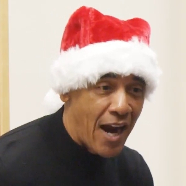 Former President Barack Obama reads an illustrated book to school children on December 9, 2025, in Chicago, Illinois, while wearing a Santa hat.