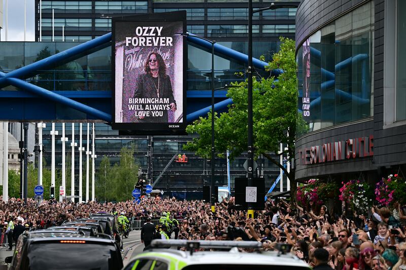 Mourners and music fans line the streets to pay their respects as the funeral cortege of Ozzy Osbourne, the late lead singer of Black Sabbath, makes its way through Birmingham, central England on July 30, 2025. Thousands are expected to line the streets in Ozzy Osbourne's UK hometown of Birmingham on Wednesday to honour the heavy metal hell-raiser Ozzy Osbourne as he is laid to rest. Osbourne, nicknamed the "Prince of Darkness" and who once bit a bat while on stage while performing with his Black Sabbath band, died on July 22 at the age of 76. (Photo by Ben STANSALL / AFP) (Photo by BEN STANSALL/AFP via Getty Images)