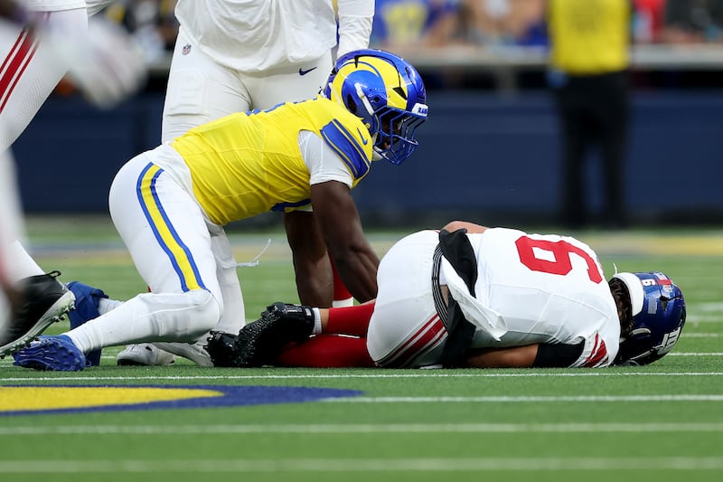 Jaxson Dart #6 of the New York Giants lays on the ground after being tackled by Byron Young #0 of the Los Angeles Rams during the first quarter of the game.