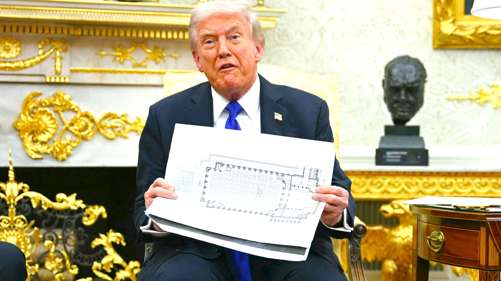 President Donald Trump shows the floor plan of his planned ballroom in the Oval Office of the White House in Washington, DC, on October 22, 2025.