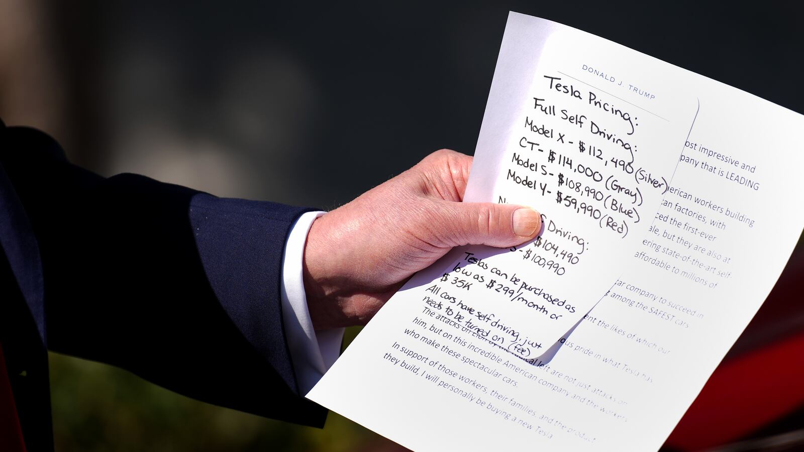 Donald Trump carried a note that included Tesla pricing during his White House stunt where he purchased a new car he says he will never drive.