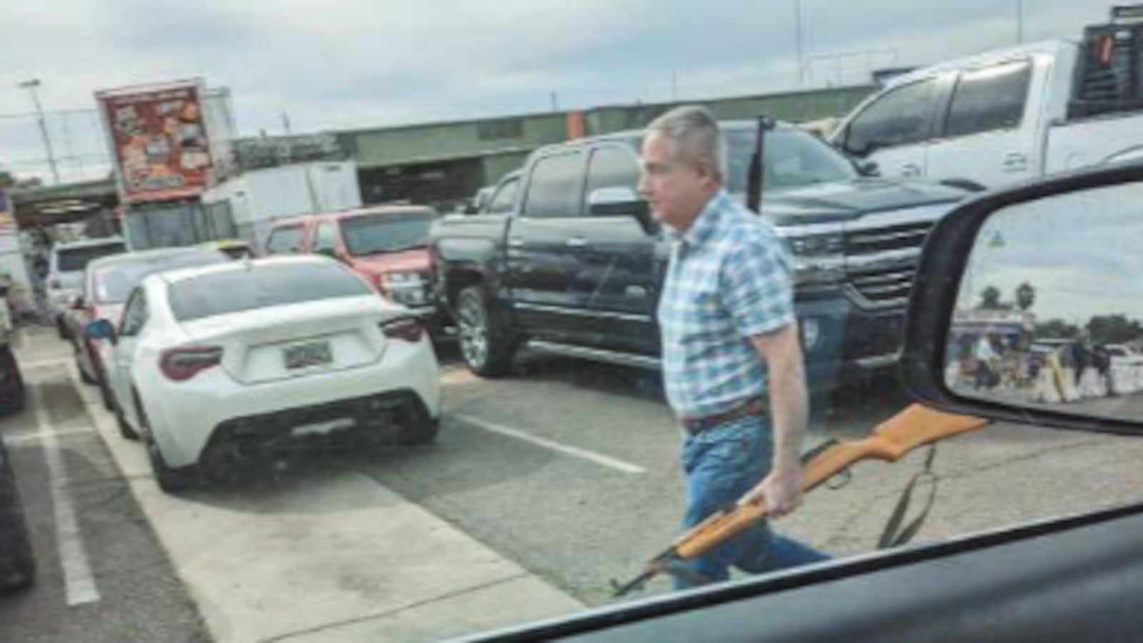Mark Adams Prieto walks with two rifles.