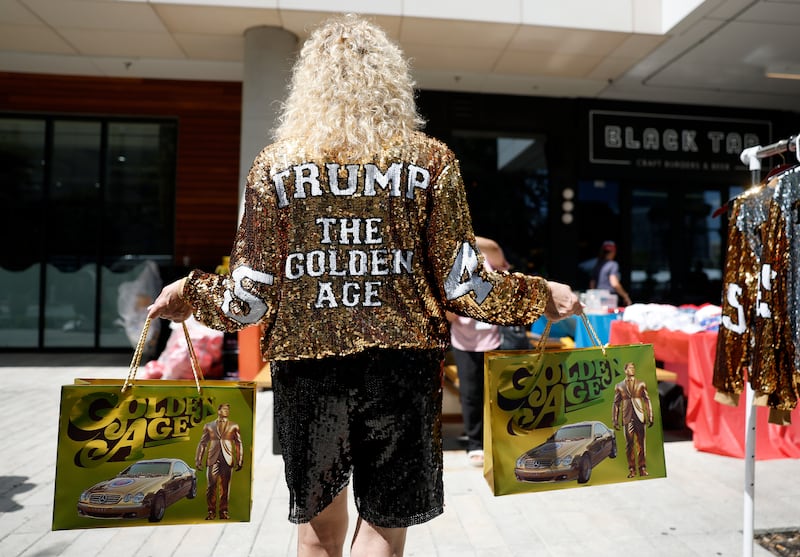 Woman in Dallas wearing jacket with words on back: TRUMP - The Golden Age