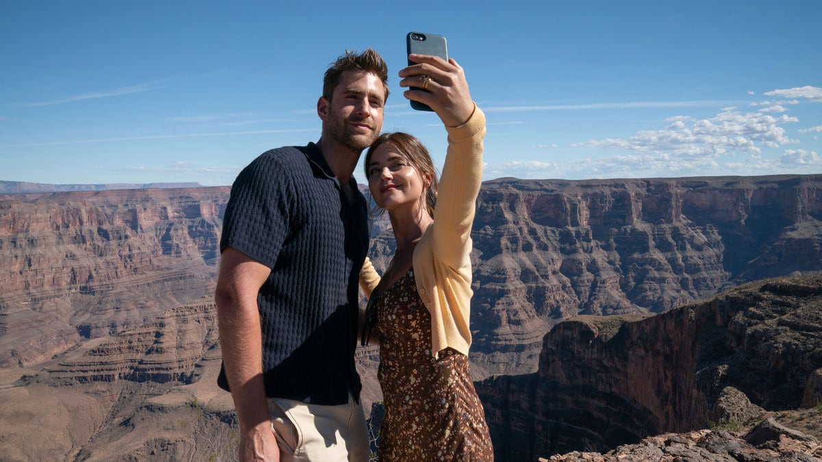 Oliver Jackson-Cohen and Jenna Coleman taking a selfie in a still of ‘Wilderness’