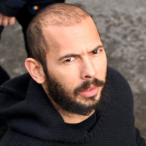 British-US influencer Andrew Tate arrives handcuffed and escorted by police at a courthouse in Bucharest on February 1, 2023.