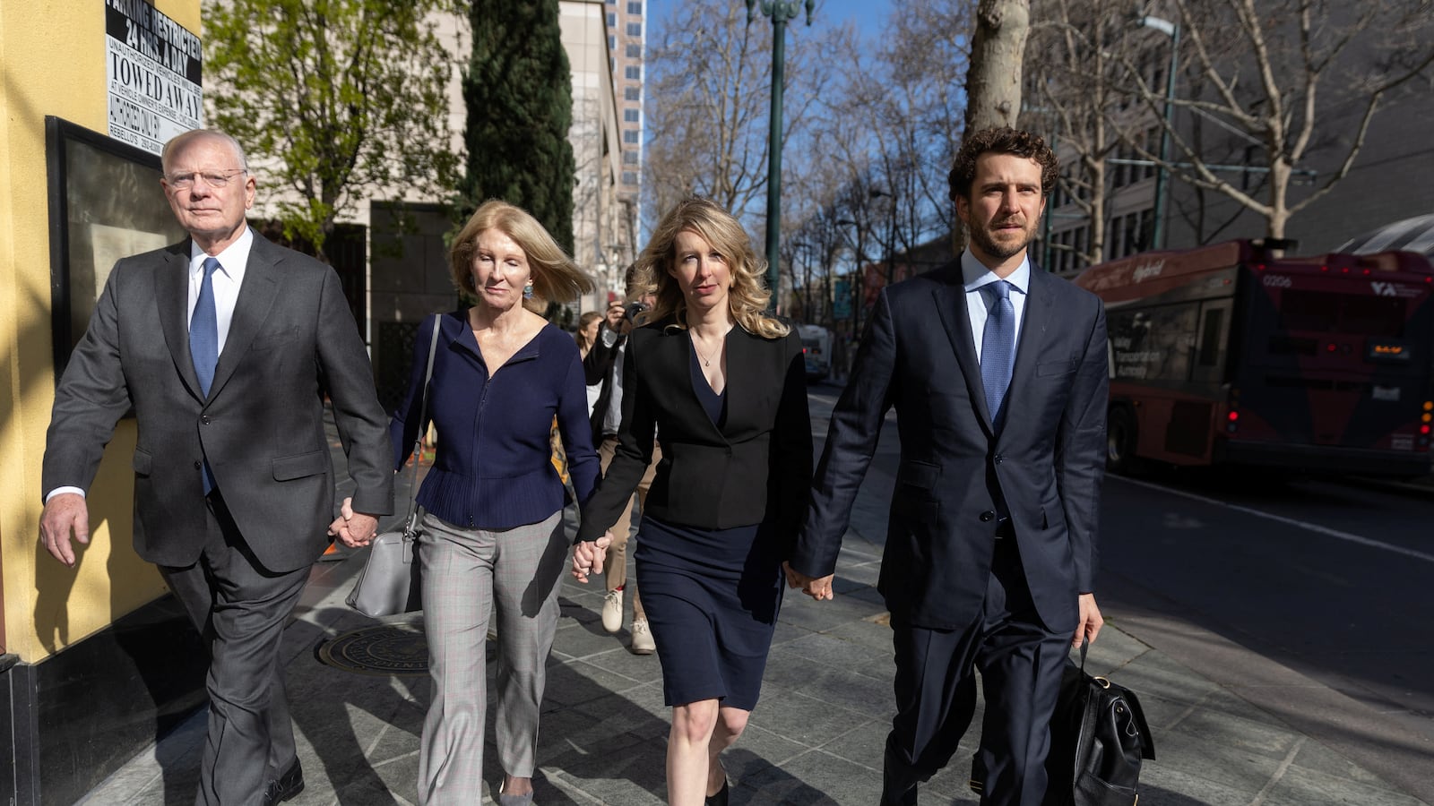 Elizabeth Holmes walks into court with her parents and partner.