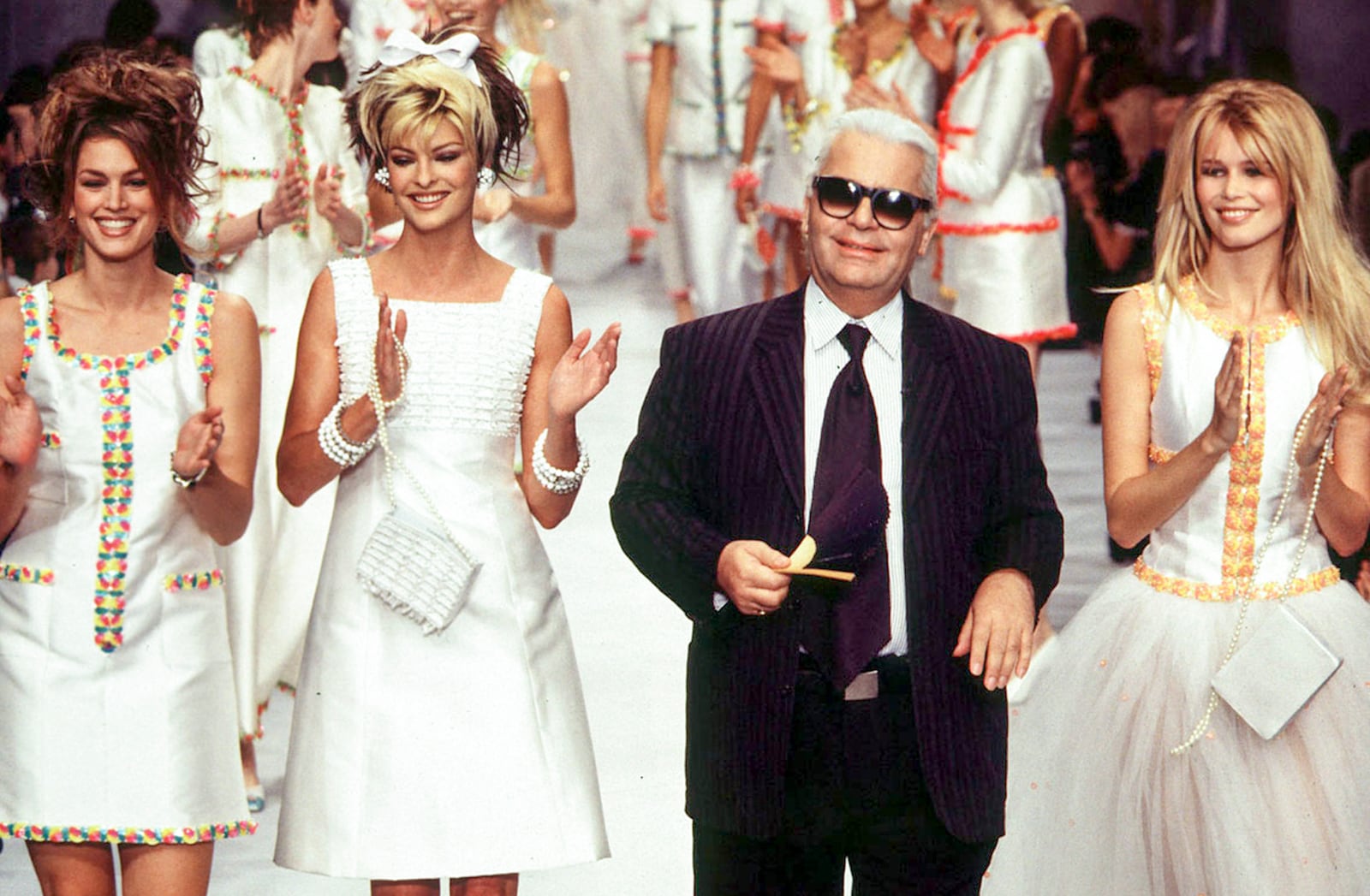 Cindy Crawford, Linda Evangelista, and Claudia Schiffer walk the runway at the Chanel Ready-to-Wear Spring/Summer 1996 fashion show, with designer Karl Lagerfeld, during Paris Fashion Week in 1995.