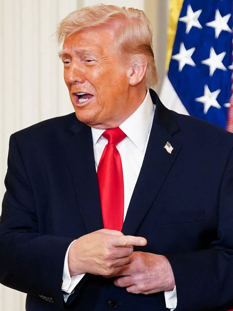 U.S. President Donald Trump reacts as bobsledder Kaillie Humphries gives him the Order of Ikkos during a Women's History Month event, in the East Room of the White House in Washington, D.C., U.S. March 12, 2026. REUTERS/Nathan Howard