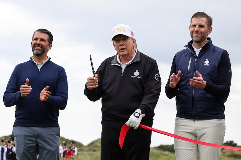 U.S. President Donald Trump holds scissors next to Eric Trump and Donald Trump Jr., after cutting the ribbon during the grand opening of Trump International Golf Links Aberdeen in Balmedie, Aberdeen, Scotland, Britain, July 29, 2025. REUTERS/Evelyn Hockstein