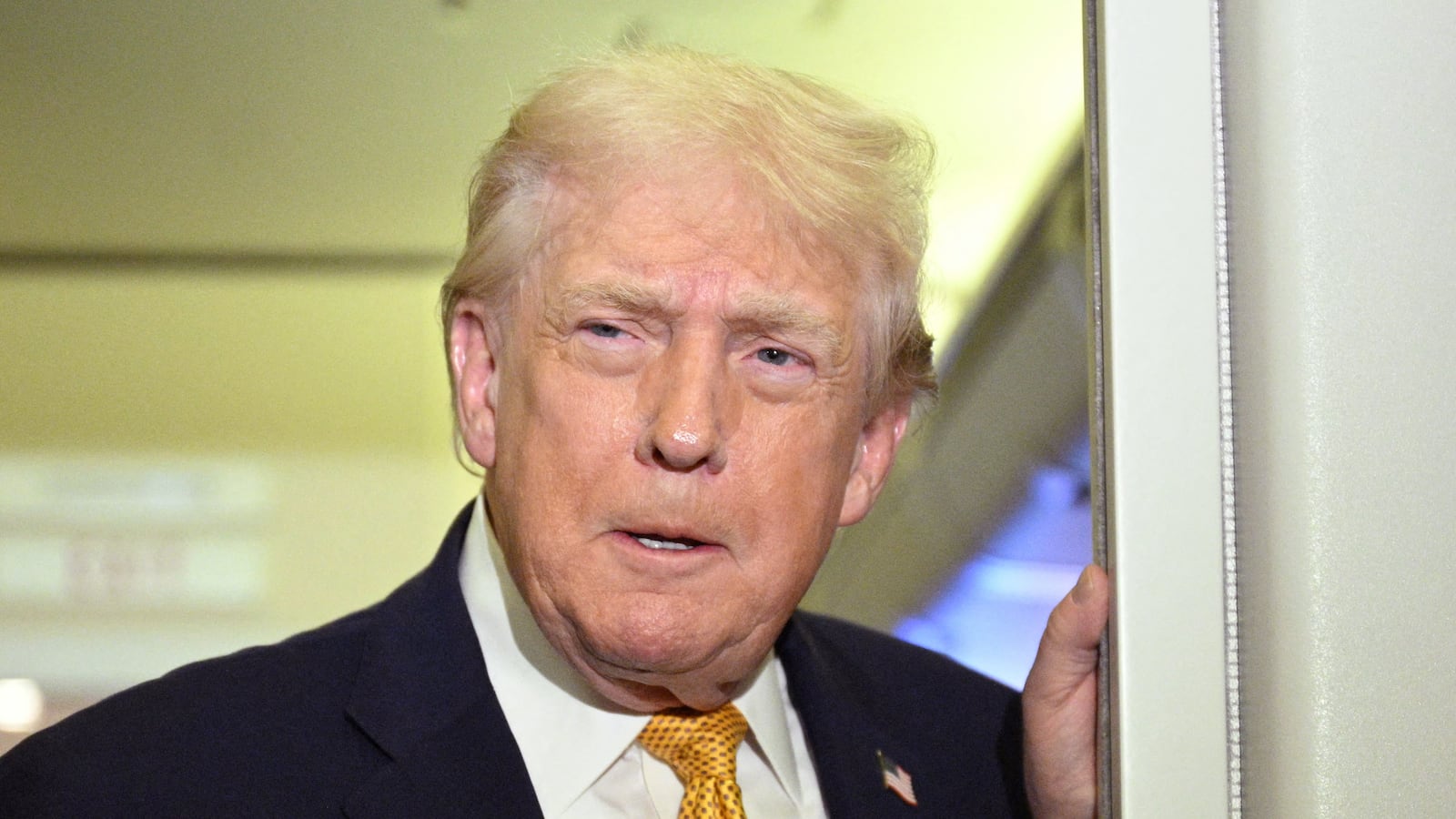 US President Donald Trump speaks with reporters aboard Air Force One
