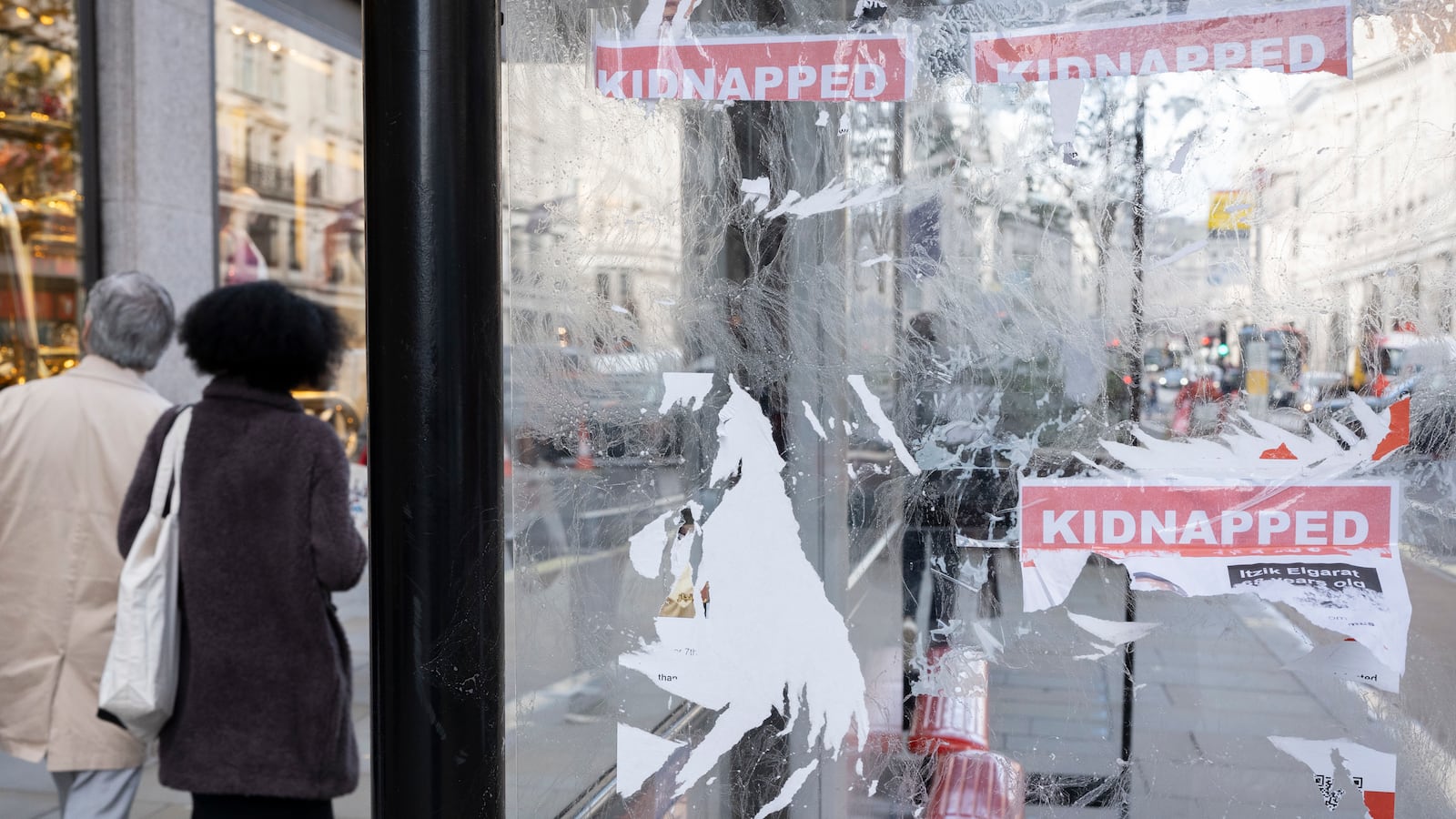 Flyers and posters showing the names and faces of Israeli hostages seized by Hamas are seen after being damaged