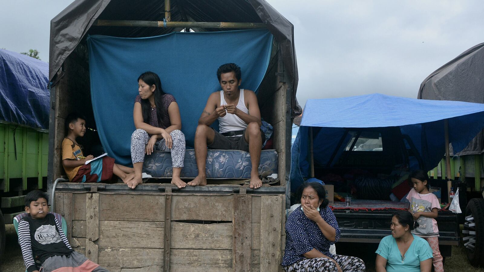Villagers who live near Mount Agung sit inside a truck as a temporary tent near a sport arena in Klungkung.