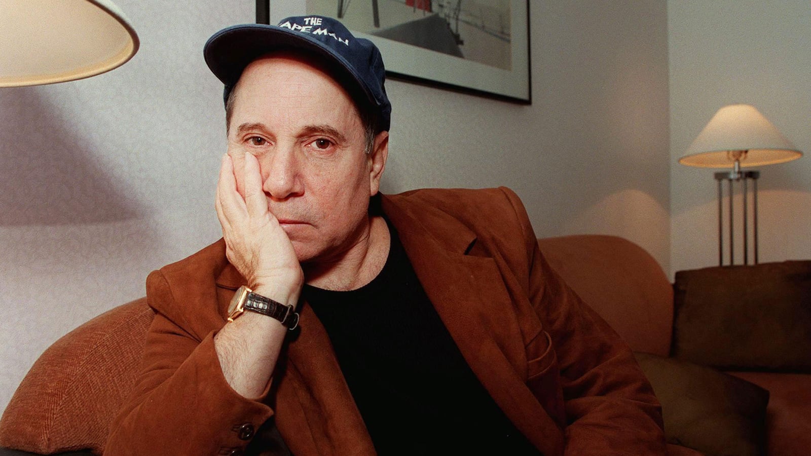 Paul Simon wearing a 'The Capeman' hat