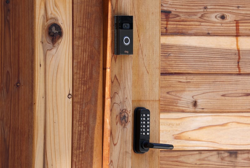 A Ring security camera is seen on the fence of a home.