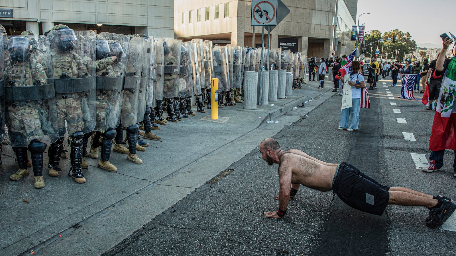 A man does push-ups in front of US Marines and Customs and Border Protection officers.