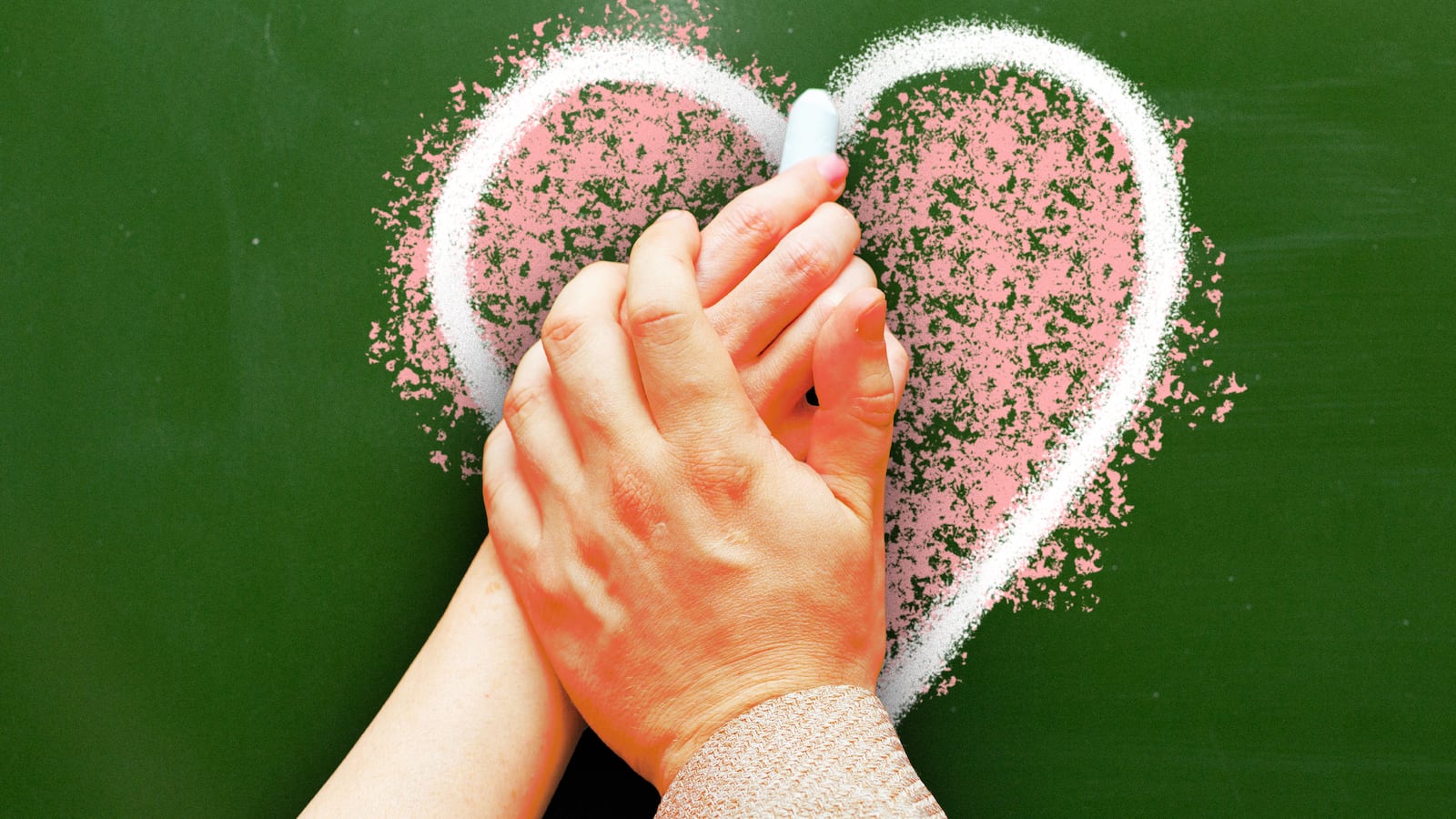A photo illustration of a teacher's hand over the hand of a student drawing a heart on a chalkboard.