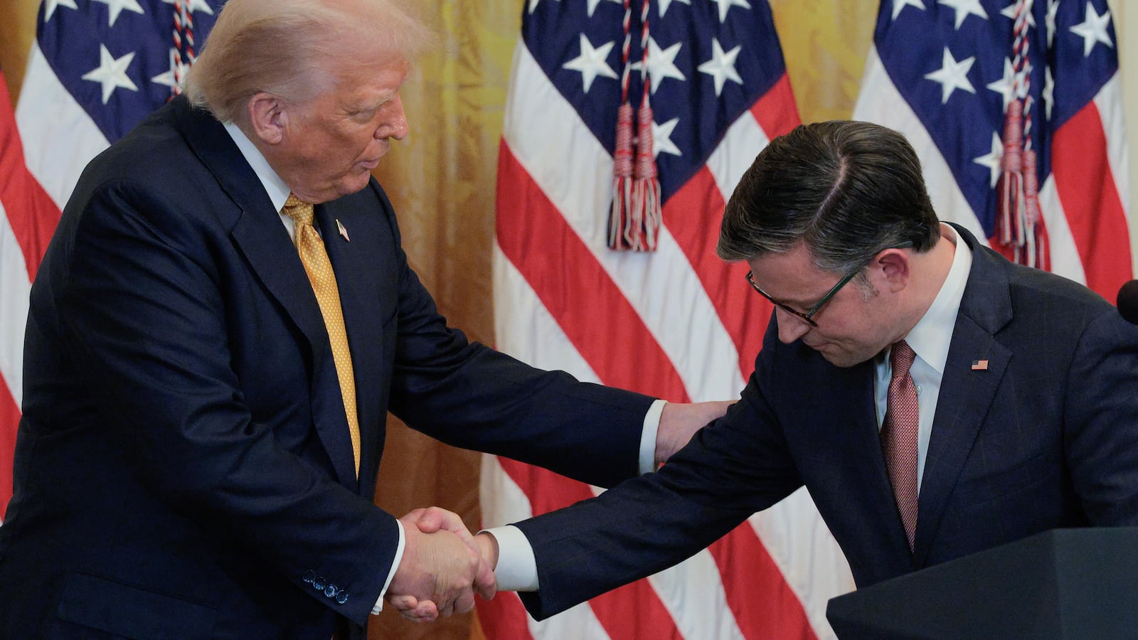 WASHINGTON, DC - JULY 22: U.S. President Donald Trump shakes hands with Speaker of the House Mike Johnson during a reception for Republican members of the House of Representatives in the East Room of the White House on July 22, 2025 in Washington, DC. Trump thanked GOP lawmakers for passing the One Big Beautiful Bill Act. (Photo by Chip Somodevilla/Getty Images)