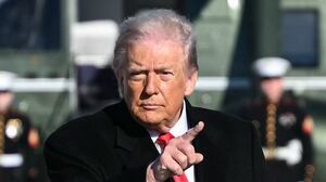 US President Donald Trump gestures as he walks to board Air Force One at Joint Base Andrews, Maryland on January 13, 2026.