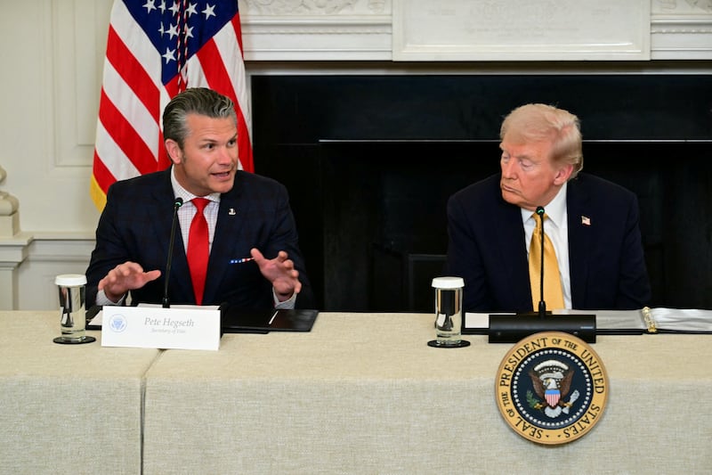 US President Donald Trump (R) listens to Defense Secretary Pete Hegseth (L) in the State Dining Room of the White House on October 23, 2025 in Washington, DC.