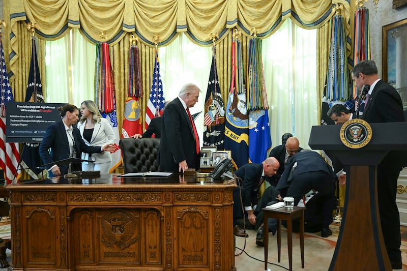 President Donald Trumps stands up and looks on after a man fainted during an announcement about weight-loss drugs in the Oval Office of the White House in Washington, DC on November 6, 2025.