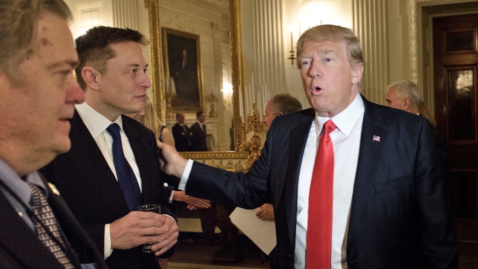 Trump advisor Steve Bannon watches as US President Donald Trump greets Elon Musk.