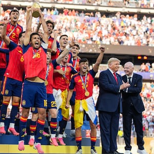 EAST RUTHERFORD, NEW JERSEY - JULY 19: US President Donald Trump and FIFA President Gianni Infantino stand on stage as Rodri #9 of Spain raises the FIFA World Cup Winner’s Trophy with his teammates after they defeated Argentina in the FIFA World Cup 2026 Final at New York New Jersey Stadium on July 19, 2026 in East Rutherford, New Jersey. Spain defeated reigning World Cup champions Argentina, who were led by Lionel Messi, with the lone goal coming from Ferran Torres #7 in the 106th minute of extra time. (Photo by Andrew Harnik/Getty Images)
