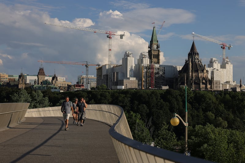 With Parliament Hill in the background, tourists use the new Pìdàban Pedestrian Bridge to walk to Kìwekì Point, in Ottawa, Ontario, Canada, August 6, 2026. REUTERS/David Kawai