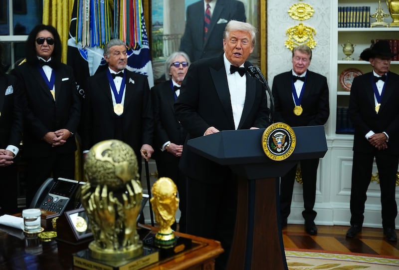 U.S. President Donald Trump delivers remarks as honorees (L-R) musician Gene Simmons of the rock band KISS, actor Sylvester Stallone, musician Peter Criss of the rock band KISS, actor Michael Crawford and country musician George Strait look on during the medal presentation ceremony for the 2025 Kennedy Center Honorees in the Oval Office of the White House on December 06, 2025 in Washington, DC.