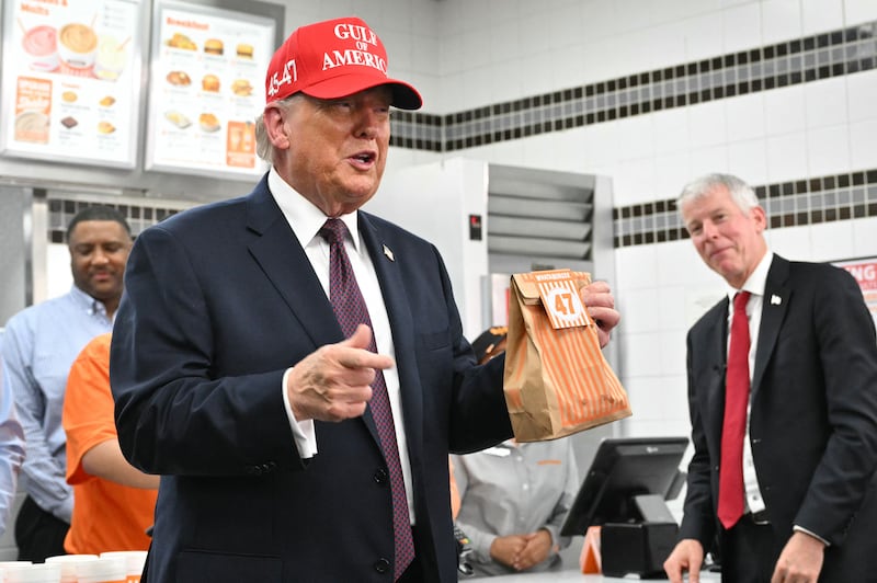 President Donald Trump holds a bag of food in a Whataburger restaurant in Corpus Christi, Texas, on February 27, 2026 just hours before posting a video announcing the U.S. had launched a massive operation against Iran.