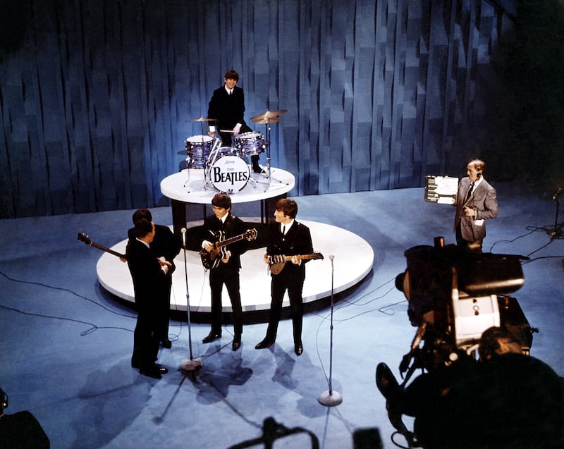 Elevated view of American television personality Ed Sullivan (1902 - 1974) (left, fore), with the members of British Rock group the Beatles, during an episode of 'The Ed Sullivan Show' at CBS's Studio 50, New York, New York, February 9, 1964. Pictured are, from left, Sullivan, Paul McCartney (mostly obscured behind Sullivan), George Harrison, Ringo Starr, (rear), and John Lennon. Though filmed on the same day as the group's debut on the show, this performance was not broadcast until February 23