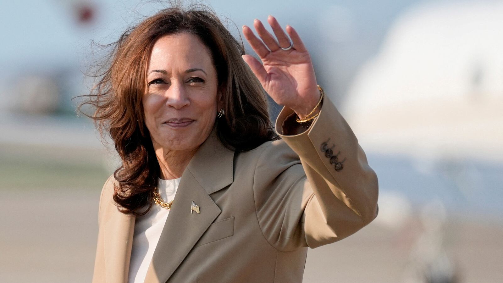 Kamala Harris waves on a tarmac.