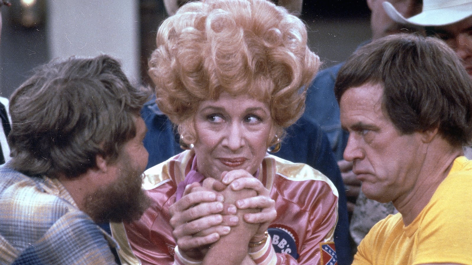Flo, portrayed by American actress Polly Holliday, referees an arm wrestling match between her bartender Geoffrey Lewis (right) and a patron in a scene from the short-lived sitcom 'Flo,' 1980. The character of Florence Jean Castleberry was spun-off from the hit television series 'Alice' due to her overwhelming popularity. (Photo by CBS Photo Archive/Getty Images)